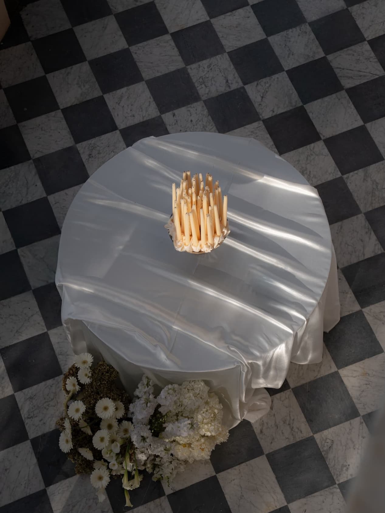 Silk-draped round table on checkered floor