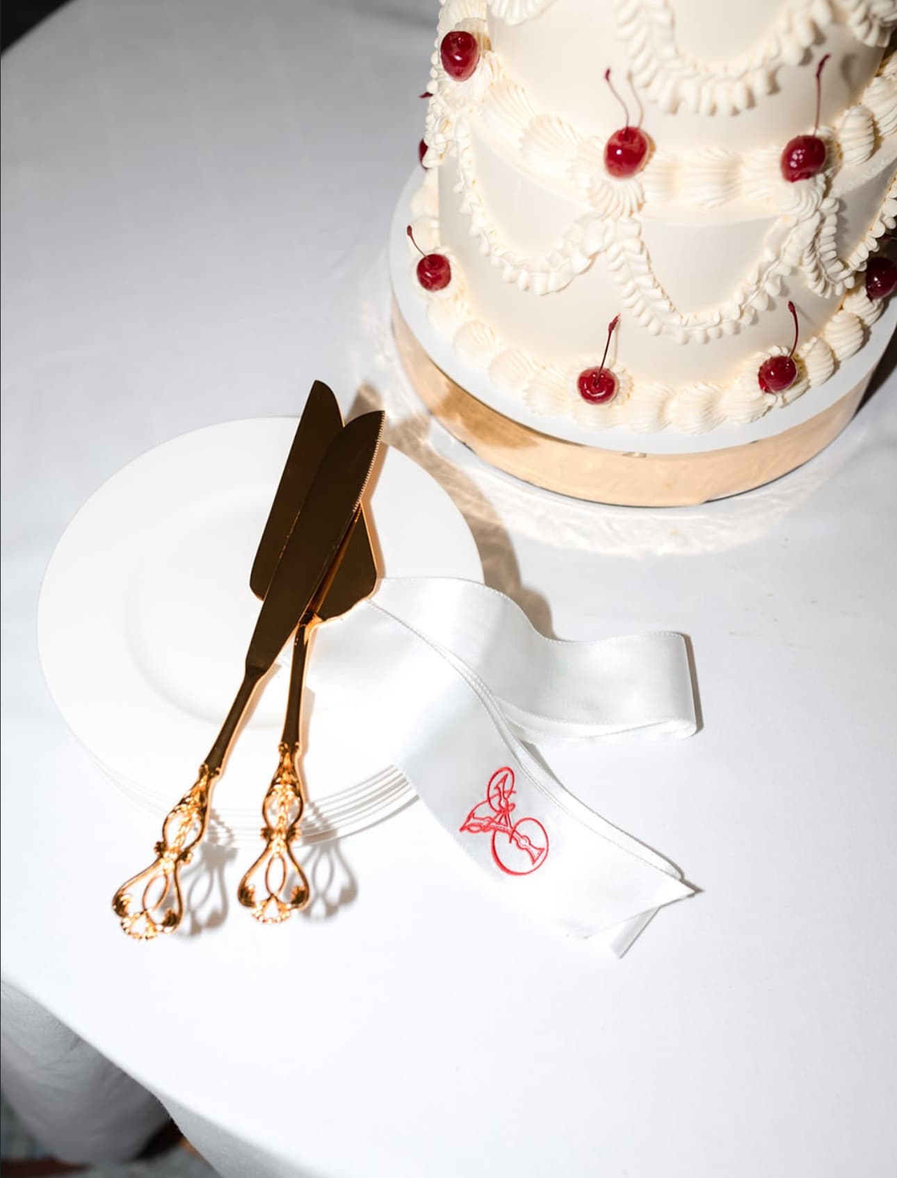 Cherry-iced cake and gold knives